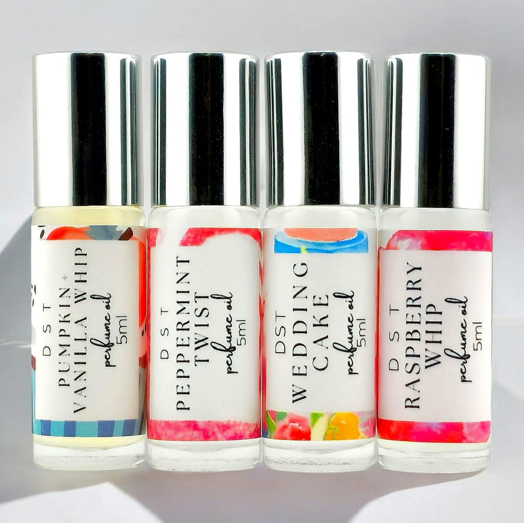 5ml bottle of Lollipop perfume spray against a grey background with 2 rainbow swirl lollipops. 