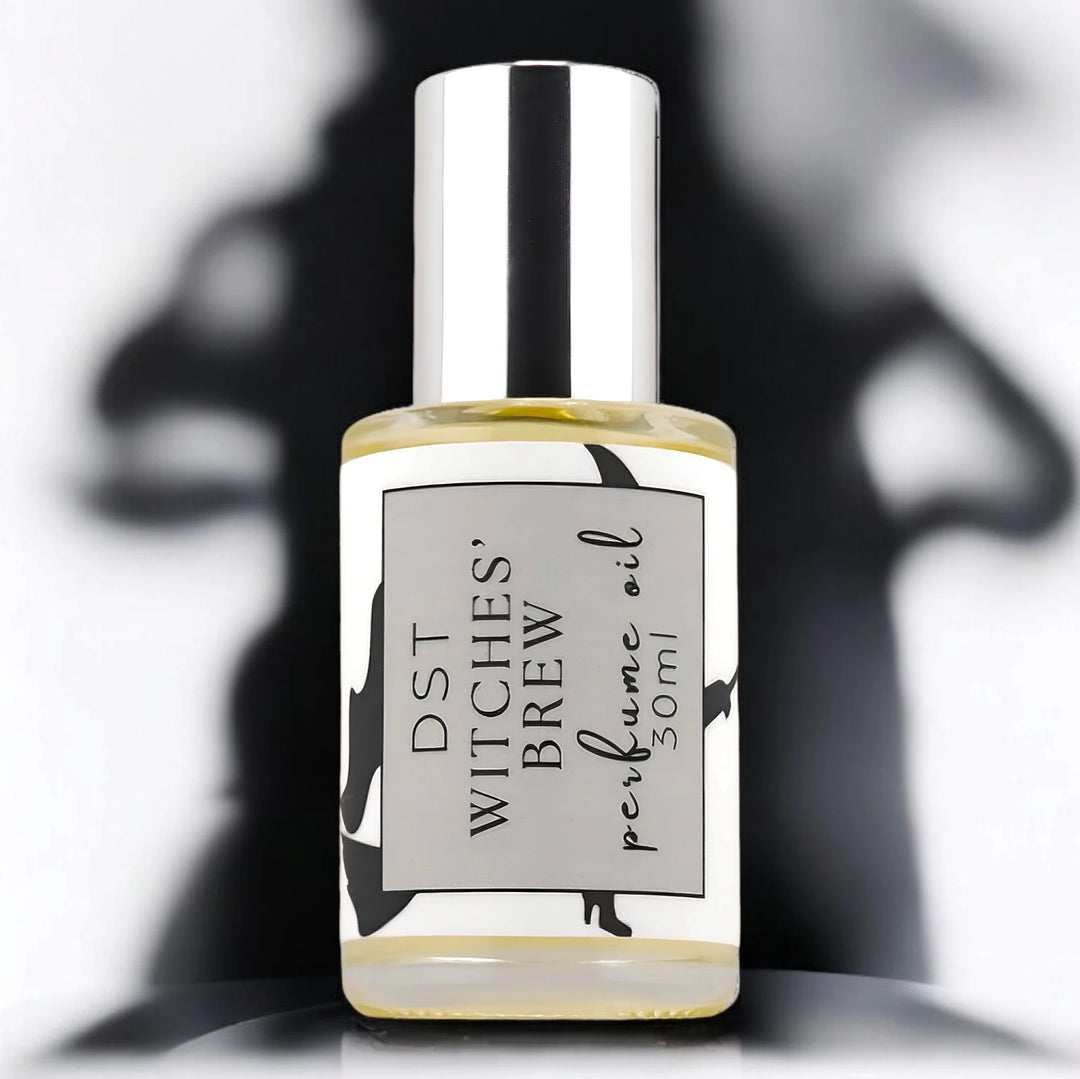 30ml bottle of Witches Brew perfume oil against a white background with spooky black shadows.