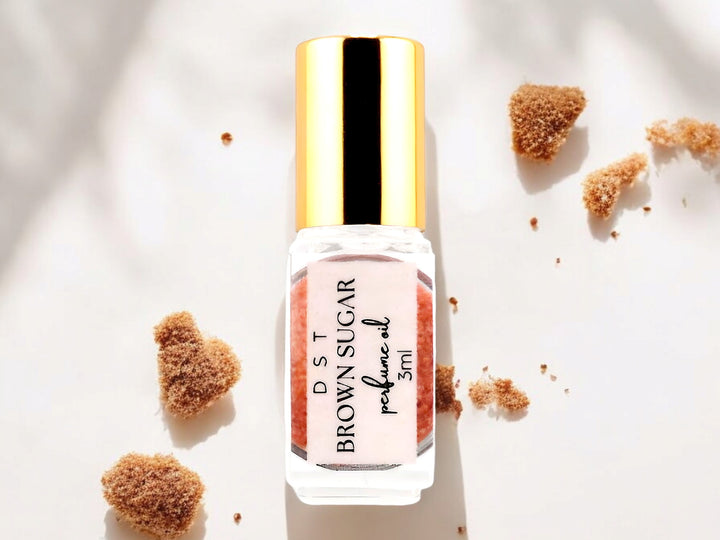 3ml bottle of Brown Sugar perfume oil resting on white surface with mounds of brown sugar.