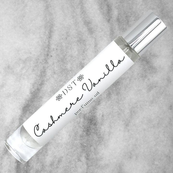 10ml bottle of Cashmere Vanilla perfume oil against a grey background. 