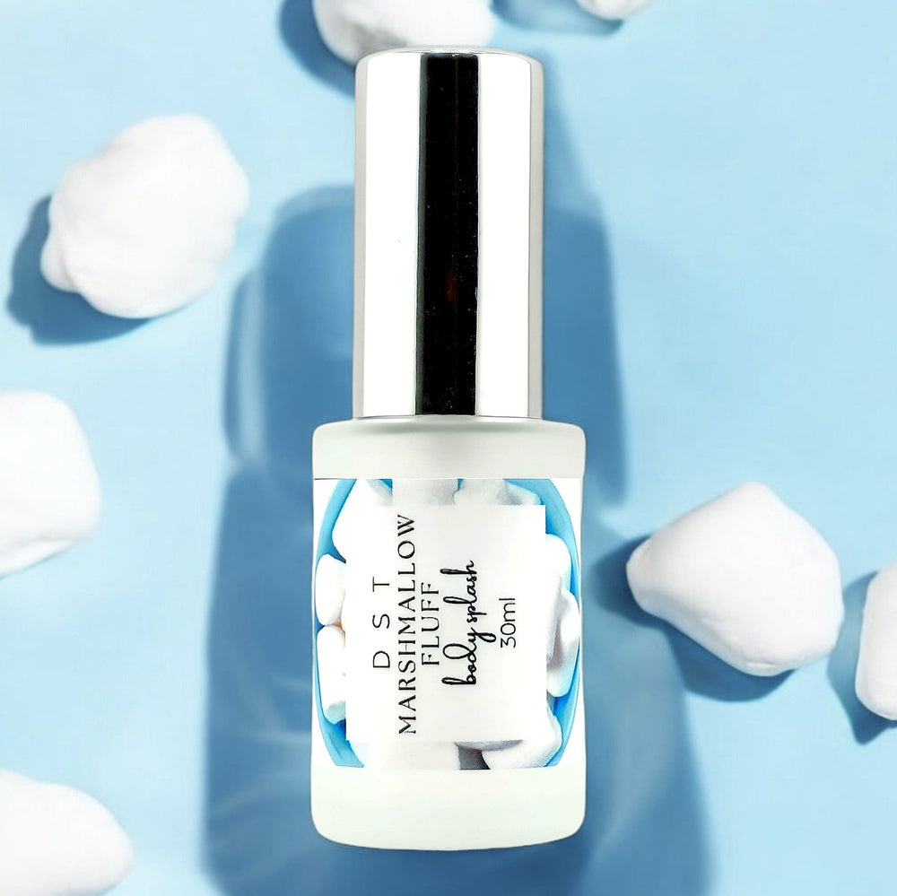 1oz bottle of Marshmallow Fluff Body Splash set on light blue background and white fluffy marshmallows. 