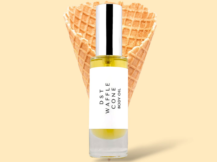 30ML bottle of Waffle Cone body oil sitting in front of a large Waffle Cone against a cream background.