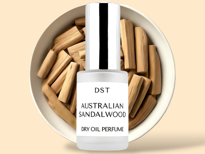 30ML bottle of Australian Sandalwood Dry Oil perfume spray sitting in front of a large white bowl filled with sandalwood against a cream background. 