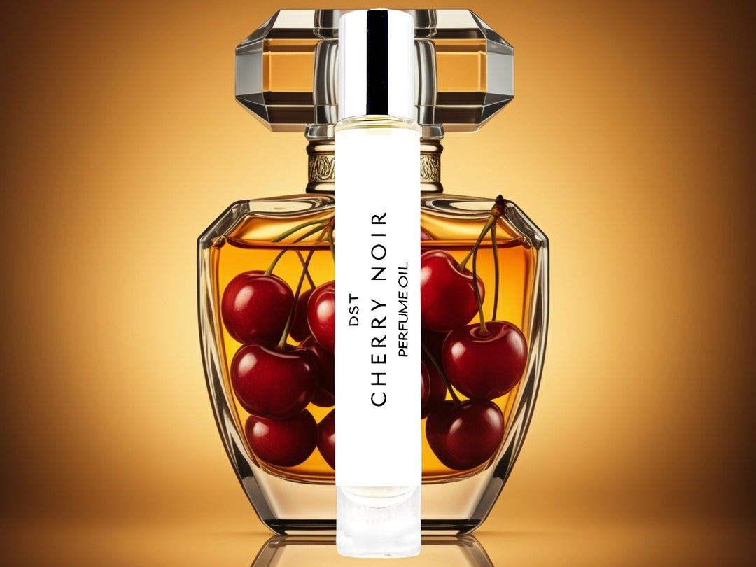 10 milliliter bottle of cherry nior perfume oil sitting in front of a large fancy perfume bottle that is filled with cherries, against an amber background.