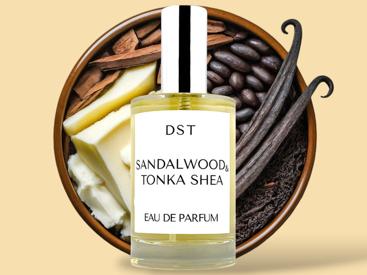 100ML bottle of Sandalwood and Tonka Shea Parfum sitting in front of a large wooded bowl filled with shea butter, tonka beans, Sandalwood, and long vanilla beans, against a tan background. 