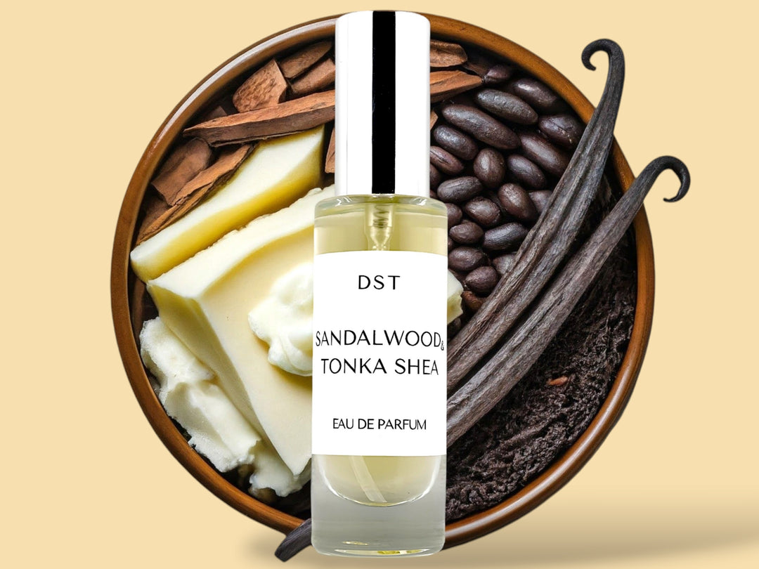 30ML bottle of Sandalwood and Tonka Shea Parfum sitting in front of a large wooded bowl filled with shea butter, tonka beans, Sandalwood, and long vanilla beans, against a tan background. 