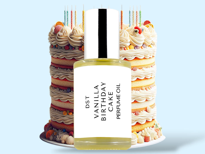 30ml bottle of Vanilla Birthday Cake Cake perfume oil sitting in front of an ornate colorful Birthday Cake topped with candles, against a light blue background.