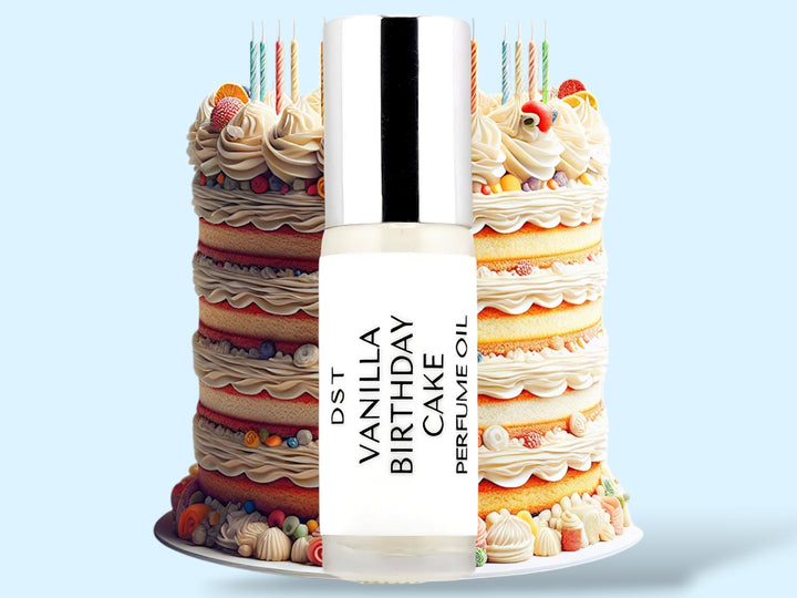 5ml bottle of Vanilla Birthday Cake Cake perfume oil sitting in front of an ornate colorful Birthday Cake topped with candles, against a light blue background.