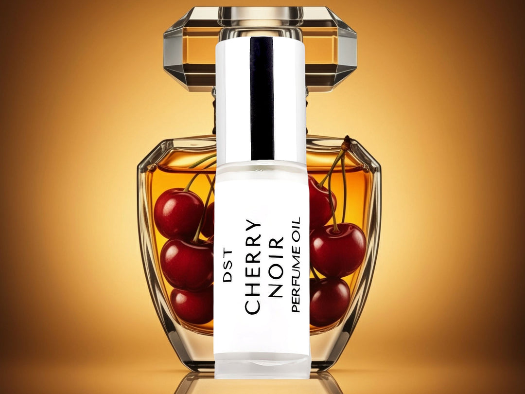 5 milliliter bottle of cherry nior perfume oil sitting in front of a large fancy perfume bottle that is filled with cherries, against an amber background.