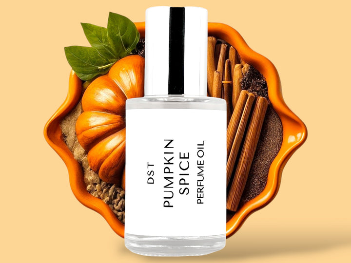 30ml bottle of Pumpkin Spice perfume oil sitting in front of an orange bowl filled with pumpkins, cinnamon sticks, and spices, against a light orange background. 