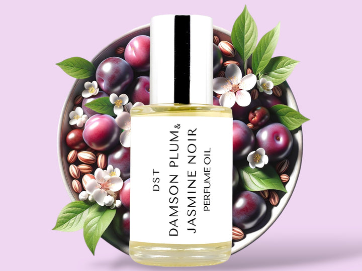 30ML bottle of Damson Plum and Jasmine Noir Perfume Oil sitting in front of a white bowl filled with purple plums and jasmine flowers against a pastel purple background. 