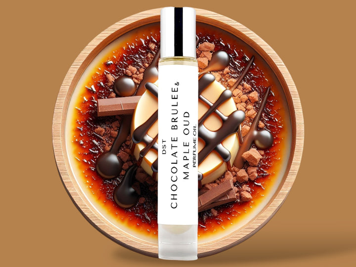 10ML bottle of Chocolate Brulee and Maple Oud perfume oil sitting in front of a large brown bowl filled with creme brulee, chocolate chunks,  and maple topping, against a light brown background. 