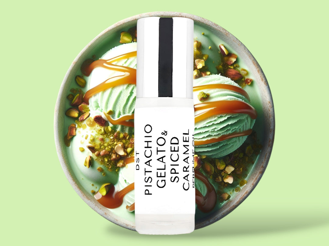 5ML bottle of Pistachio Gelato and Spiced Caramel perfume oil sitting in front of a large green bowl filled with pistachio gelato, crushed pistachios,  and caramel topping, against a light green background. 