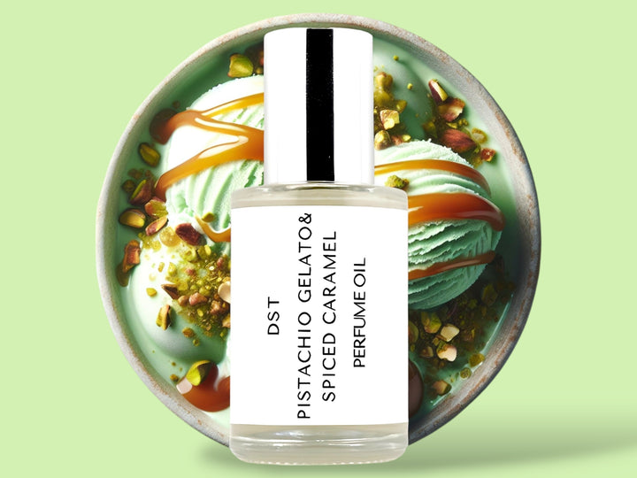 30ML bottle of Pistachio Gelato and Spiced Caramel perfume oil sitting in front of a large green bowl filled with pistachio gelato, crushed pistachios,  and caramel topping, against a light green background. 