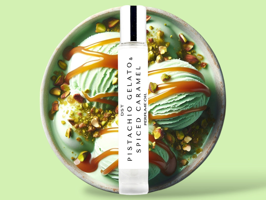 10ML bottle of Pistachio Gelato and Spiced Caramel perfume oil sitting in front of a large green bowl filled with pistachio gelato, crushed pistachios,  and caramel topping, against a light green background. 