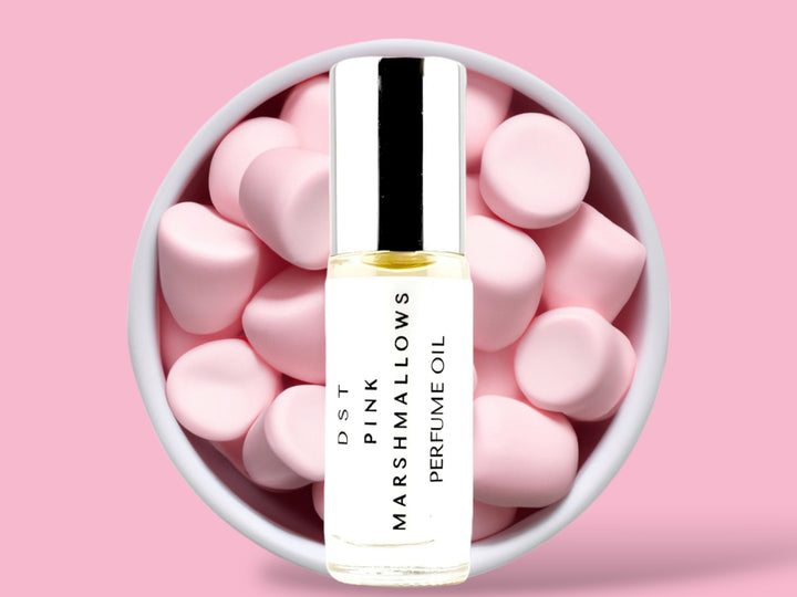 5ml bottle of Pink Marshmallows Perfume Oil sitting in front  of a large white bowl filled with Pink Marshmallows against a pink background. 