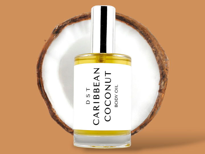 100ml bottle of Caribbean Coconut body oil sitting in front of a large opened Coconut against a brown background. 