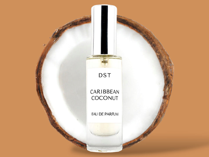 30ml bottle of Caribbean Coconut Parfum sitting in front of a large opened Coconut against a brown background. 