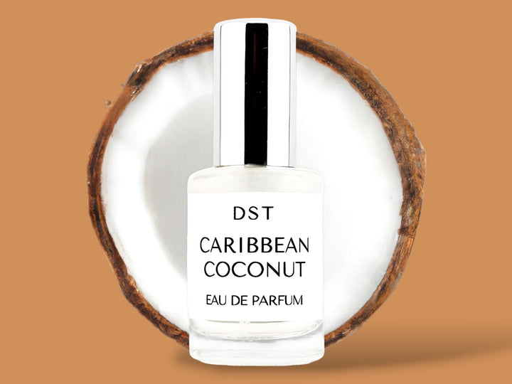 10ml bottle of Caribbean Coconut Parfum sitting in front of a large opened Coconut against a brown background. 