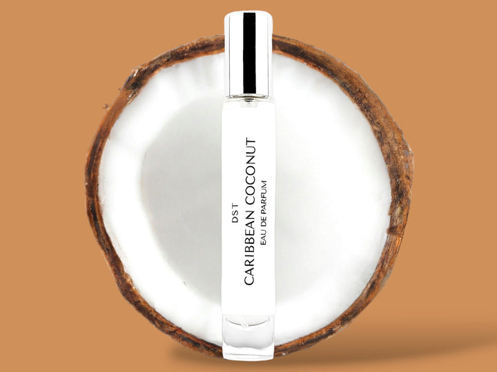 10ml bottle of Caribbean Coconut Parfum sitting in front of a large opened Coconut against a brown background. 