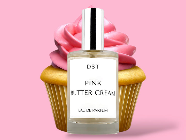 100ml bottle of Pink Butter Cream Parfum sitting in front of a large vanilla cupcake with bright pink frosting against a pink background. 