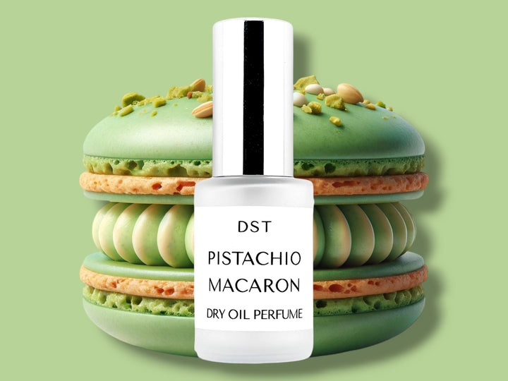 30ML bottle of Pistachio Macaron Dry Oil Perfume Spray sitting in front of a large Pistachio Macaron against a green background. 