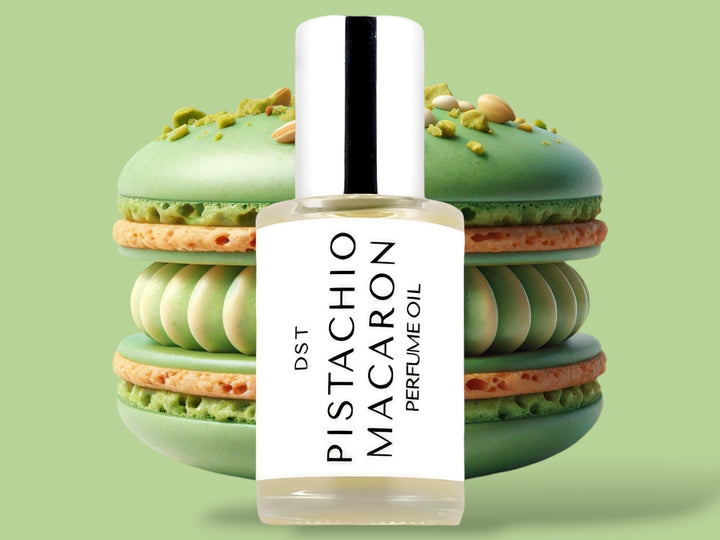 30ml bottle of Pistachio Macaron Perfume Oil sitting in front  of a large green macaron against a green background. 