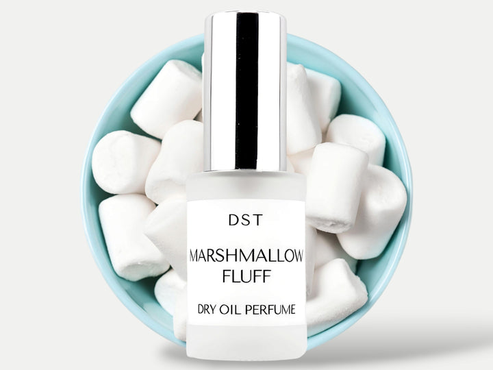 1oz Bottle of Marshmallow Fluff dry oil perfume spray set in front of a blue bowl filled with white marshmallows on Light grey background. 