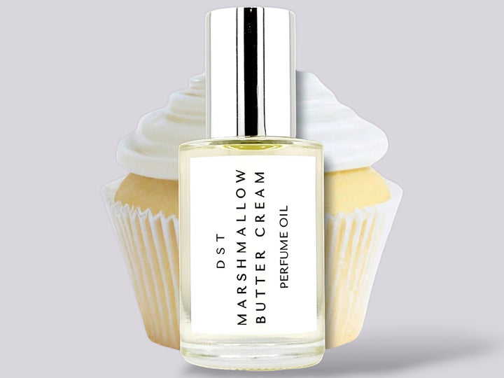 30ml bottle of Marshmallow Butter Cream Perfume Oil sitting in front  of a large vanilla cupcake against a gret background. 