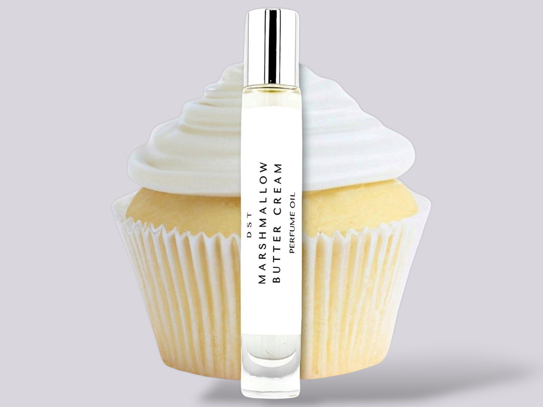 10ml bottle of Marshmallow Butter Cream Perfume Oil sitting in front  of a large vanilla cupcake against a gret background. 