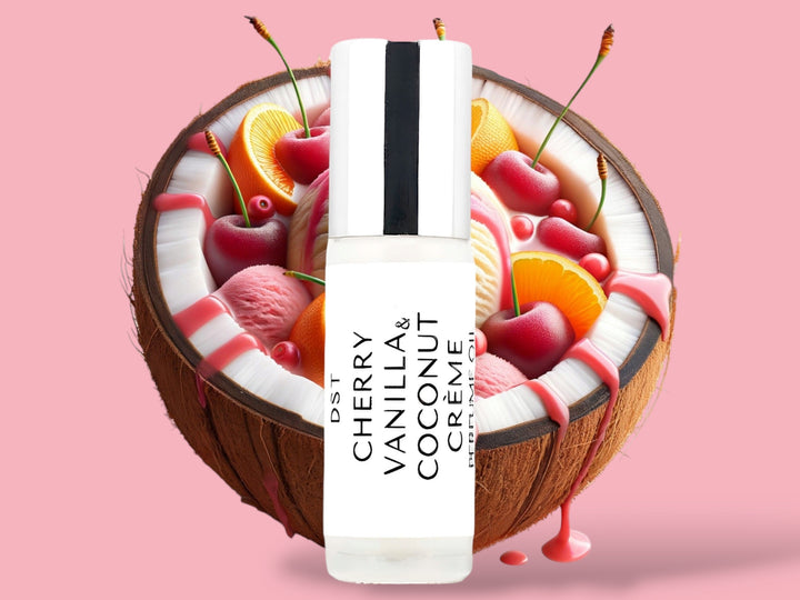 5ml bottle of Cherry Vanilla and Coconut Creme perfume oil sitting in front of a large split Coconut filled with Cherries, orange slices, and cherry syrup drizzle against a pink background.