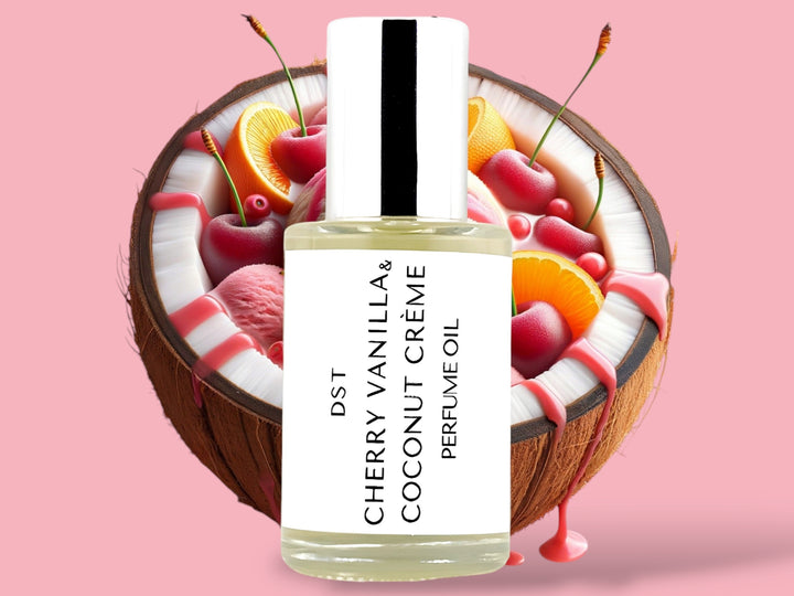 30ml bottle of Cherry Vanilla and Coconut Creme perfume oil sitting in front of a large split Coconut filled with Cherries, orange slices, and cherry syrup drizzle against a pink background.