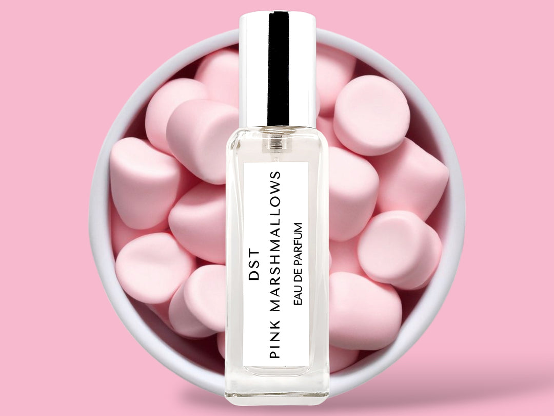 20ML bottle of Pink Marshmallows Eau de Parfum sitting in front of a large white bowl filled with fluffy pink marshmallows against a pastel pink background. 