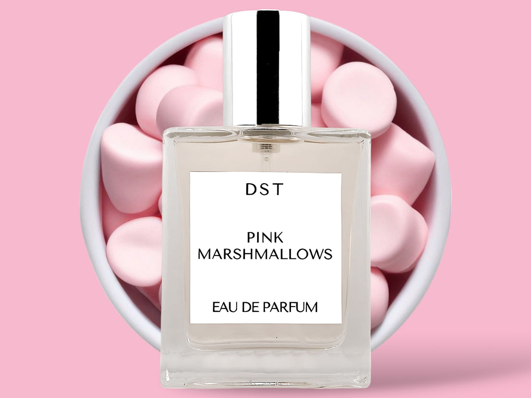 50ML bottle of Pink Marshmallows Eau de Parfum sitting in front of a large white bowl filled with fluffy pink marshmallows against a pastel pink background. 