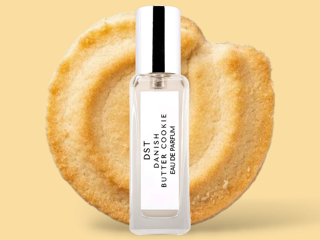 20ML bottle of Danish Butter Cookie Eau de Parfum sitting in front of a large Butter cookie against a pastel yelloe background. 