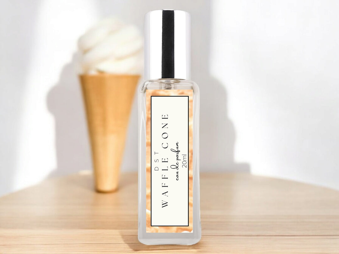 20ml bottle of Waffle Cone Eau de Parfum sitting on wood counter top with Vanilla ice cream cone in the light grey background.