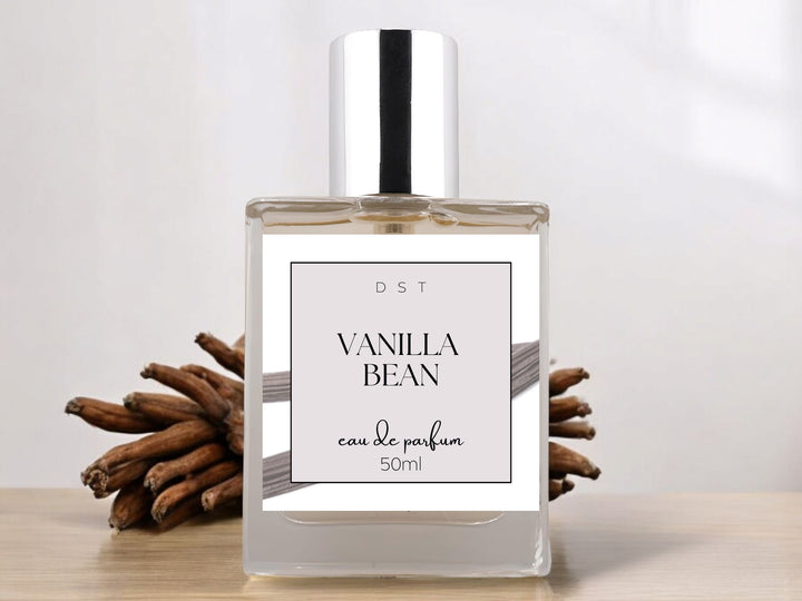 50ml bottle of Vanilla Bean Parfum sitting on a white countertop with a bundle of vanilla beans in the light grey background. 