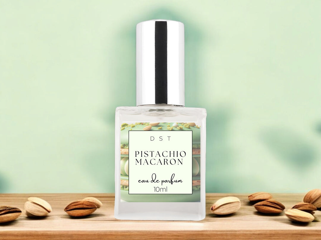 10ml bottle of Pistachio Macaroon Eau de Parfum sitting on wood counter top with pastel green background and pistachios surrounding the bottle.