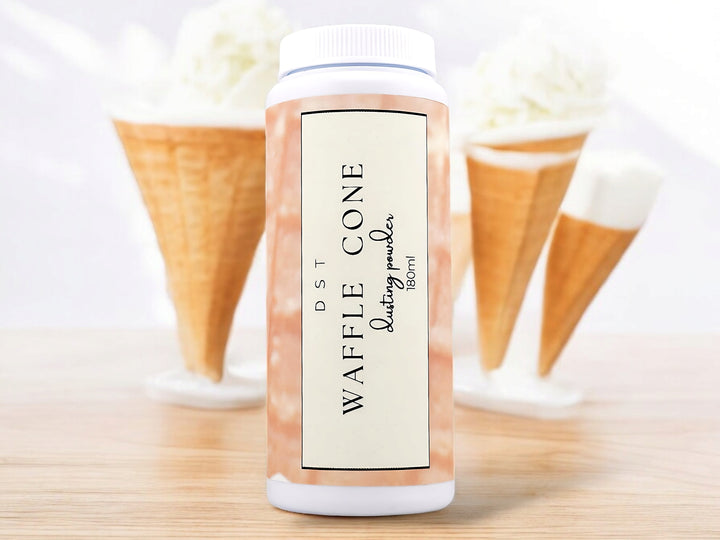 180ml bottle of Waffle Cone scented Body Powder sitting on wood counter top with 3 Vanilla ice cream cones in the white background.