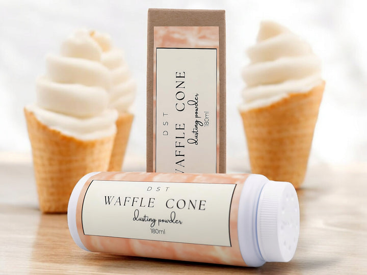 180ml bottle of Waffle Cone scented body powder and the box it is packaged in sitting on wood counter top with 3 vanilla ice cream cones in the white background.