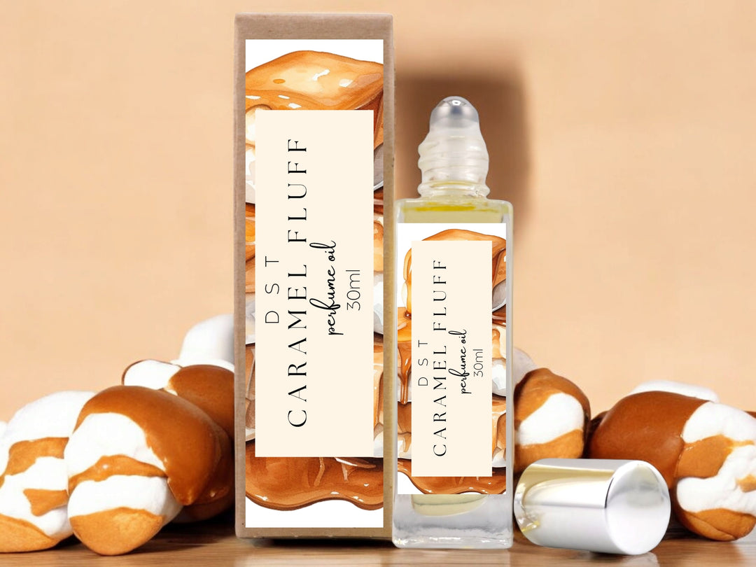 30ml bottle of caramel fluff perfume oil and the box it is packaged in on tan background with white marshmallows covered in caramel