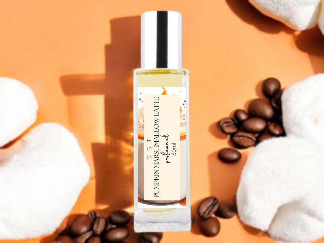 30ml bottle of marshmallow pumpkin latte perfume oil on orange background with white marshmallows and coffee beans