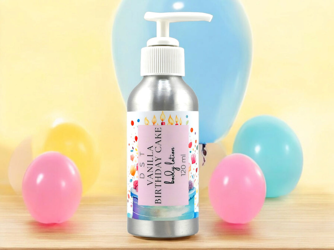 4oz Bottle of Vanilla Birthday Cake scented Body lotion sitting on a wood counter top with pink, and blue party balloons against a yellow background.