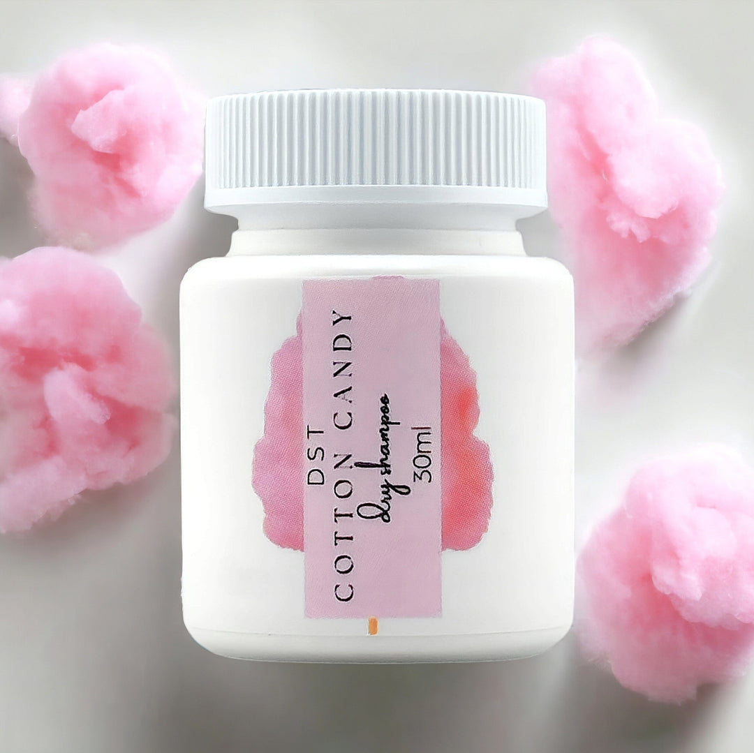 30ml bottle of Cotton Candy scented Dry Shampoo powder against white background with pink cotton candy. 