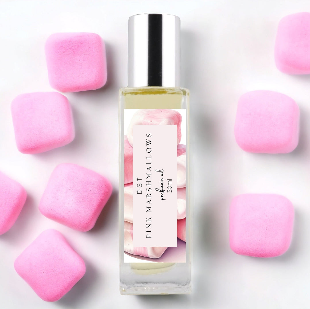 30ml bottle of Pink Marshmallows Perfume Oil against a white background surrounded by puffy pink Marshmallows. 