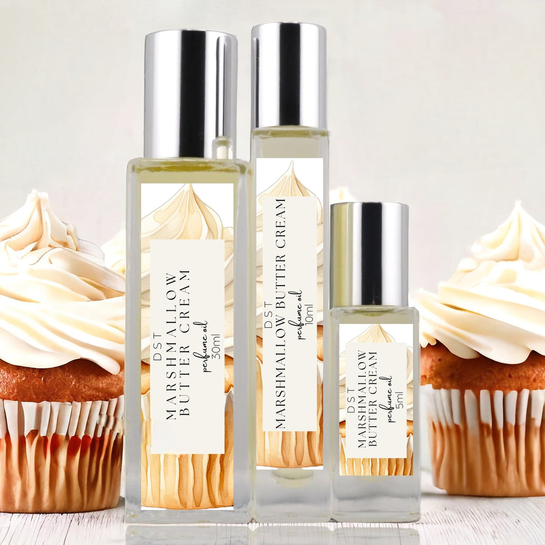 5, 10, and 30ml bottles of Marshmallow Butter Cream Perfume Oil against a grey background with several cupcakes topped with Marshmallow Frosting. 