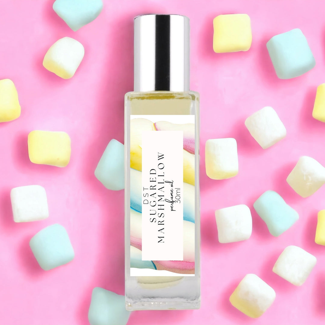 30ml bottle of Sugared Marshmallow perfume oil against pink background with pastel colored Marshmallows.