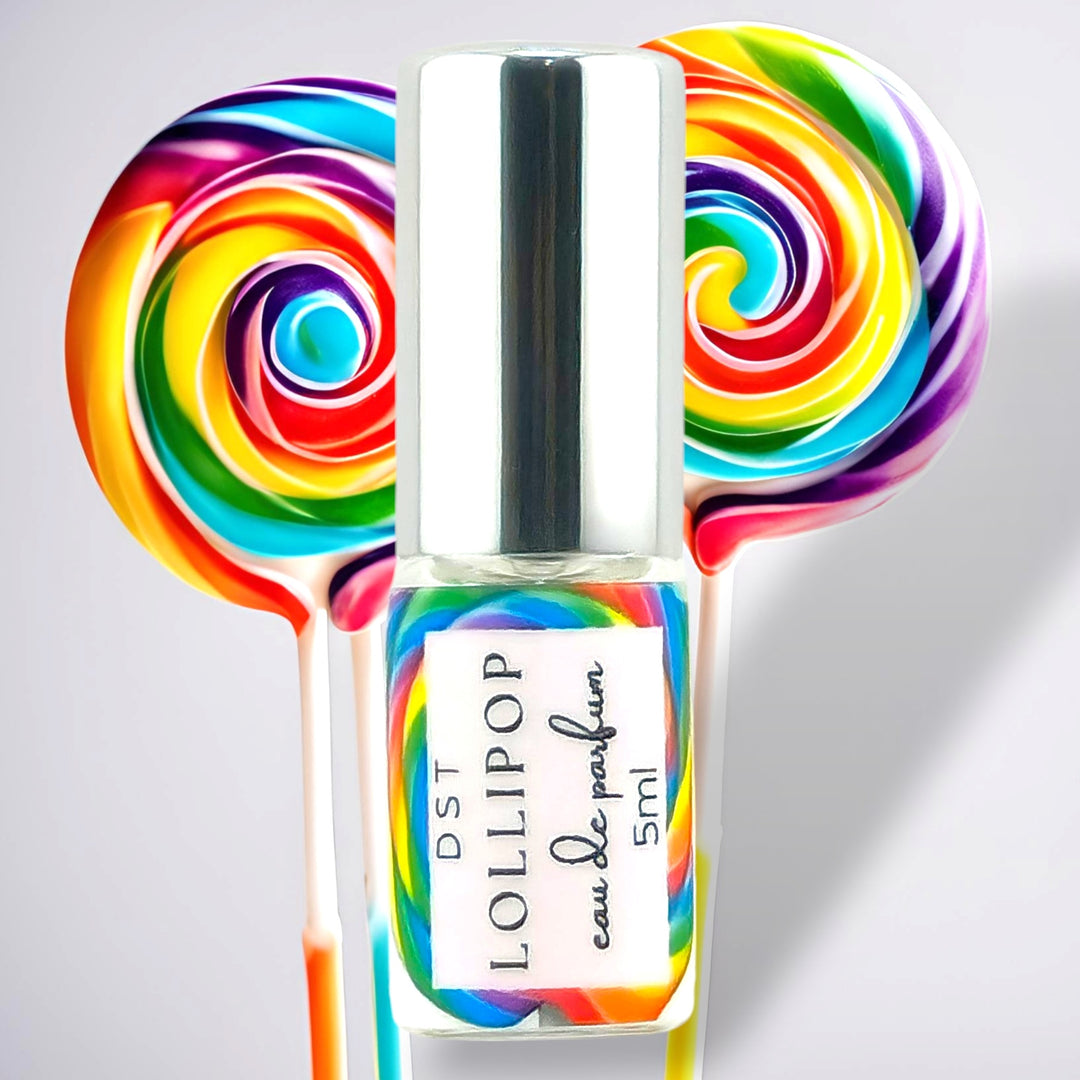 5ml bottle of Lollipop perfume spray against a grey background with 2 rainbow swirl lollipops. 