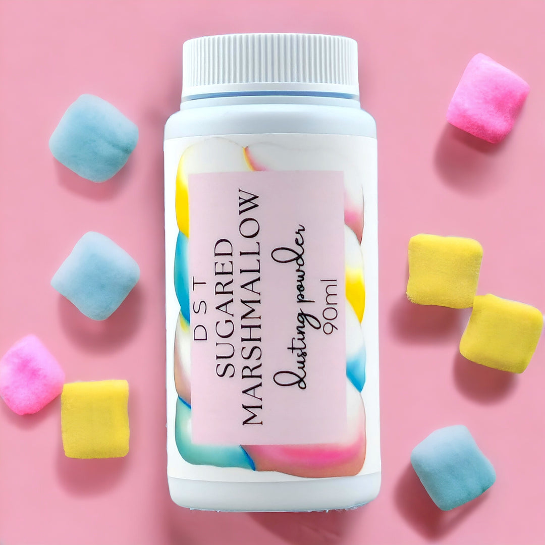 90ml bottle of Sugared Marshmallow scented body powder against a pink background with pastel colored Marshmallows. 