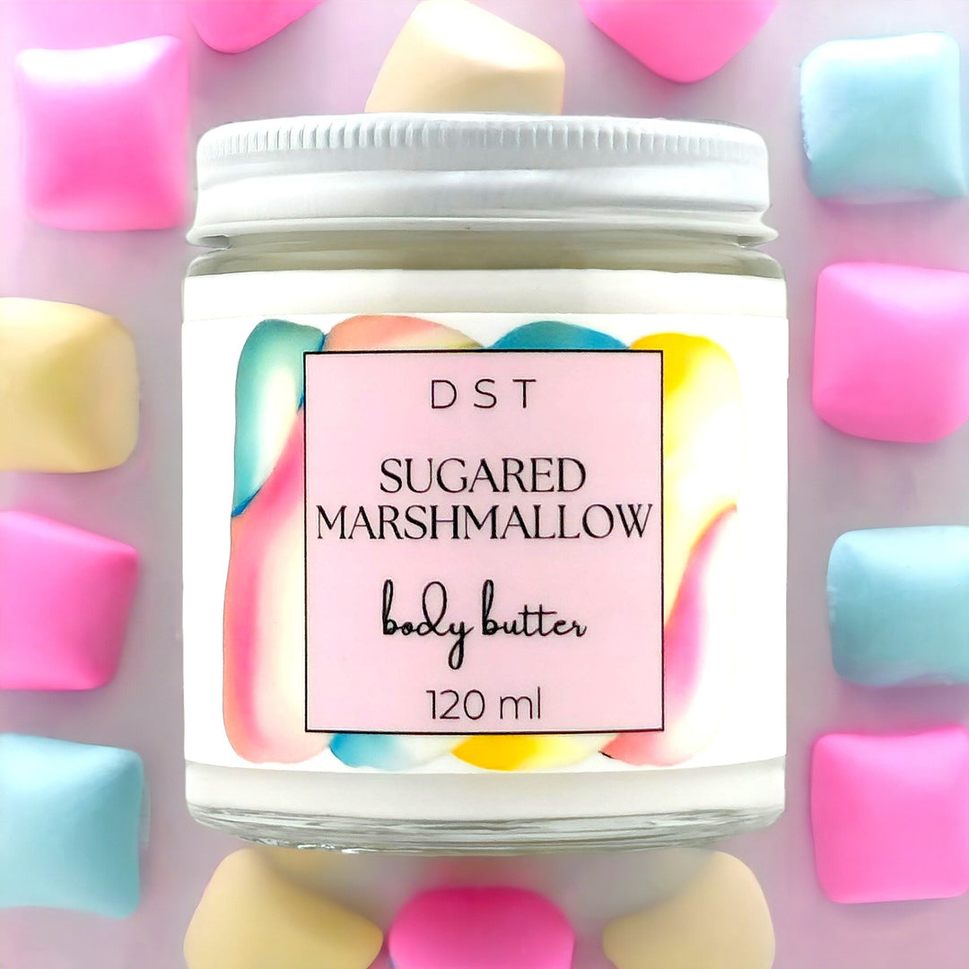 120ml jar of Sugared Marshmallow scented body butter against a light purple background with pastel colored Marshmallows. 